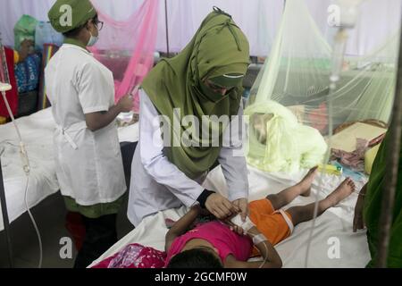 Dhaka, Bangladesh. 09e août 2021. Une infirmière s'occupe d'une fille qui a été infectée par la dengue à l'hôpital pour enfants. Le Bangladesh combat l'épidémie de dengue dans le contexte de la crise de la COVID, une forte augmentation des cas de dengue souche le système de santé du Bangladesh déjà frappé par une aggravation de la crise de la COVID dans le pays. Ce mois-ci, 1,920 personnes ont reçu un diagnostic de la maladie transmise par les moustiques, l'augmentation des patients infectés par la dengue à partir de juin ayant atteint 272 cas. Le 8 août 2021 à Dhaka, au Bangladesh. (Photo d'Eyepix/Sipa USA) crédit: SIPA USA/Alay Live News Banque D'Images