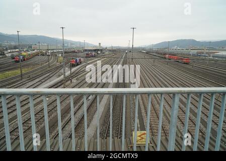 ZURICH, SUISSE - 17 mars 2018 : vue sur une ligne de train depuis une clôture métallique et le ciel, montagnes à l'horizon à Zurich, Suisse Banque D'Images