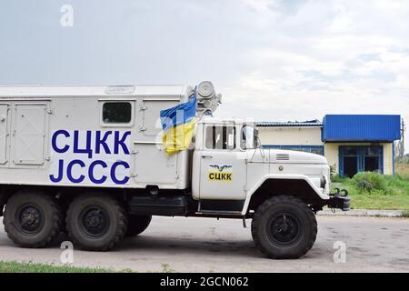 Krasnogorivka, Ukraine. 08 août 2021. Le camion de la JCCC (Commission mixte de contrôle et de coordination) est vu sur la route dans la banlieue de Krasnogorivka. Un immeuble résidentiel de Krasnogorivka a été bombardé dans la matinée du 5 août. Un civil a été gravement blessé dans son propre appartement. Le conflit armé dans l'est de l'Ukraine continue de faire un lourd tribut aux civils, depuis la menace de leur sécurité physique jusqu'à la limitation de l'accès à la nourriture, aux médicaments, aux logements adéquats et aux écoles. Crédit : SOPA Images Limited/Alamy Live News Banque D'Images