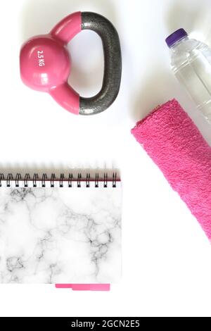 Sport fitness accessoires féminins, pose à plat, bloc-notes rose pour maquette, espace de copie. Accessoire et équipement de gym de couleur rose féminine. Fitness et style de vie sain, maquette Banque D'Images