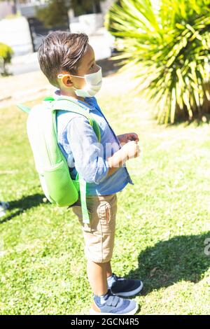 Portret vertical d'un garçon avec masque et sac à dos dans un parc Banque D'Images