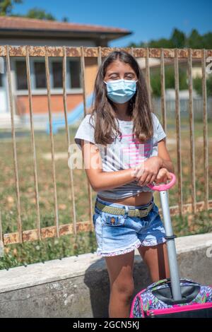 Enfant avec masque de visage qui retourne à l'école après Covid-19 quarantaine et verrouillage Banque D'Images