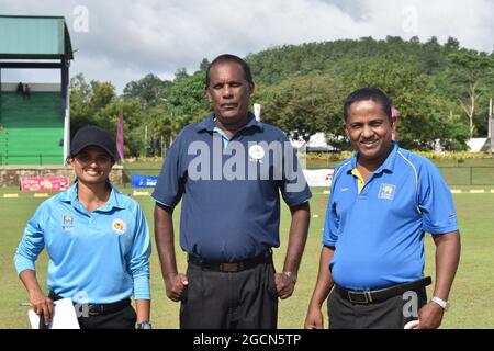 Un arbitre de cricket féminin au Sri Lanka avec des arbitres masculins lors d'un match de cricket au terrain de cricket de l'Armée de terre, Dombagoda. Les femmes qui ont été impliquées dans le cricket en tant que joueurs sont en train de prendre des arbitres et de marquer pour être impliquées dans le jeu. Sri Lanka. Banque D'Images