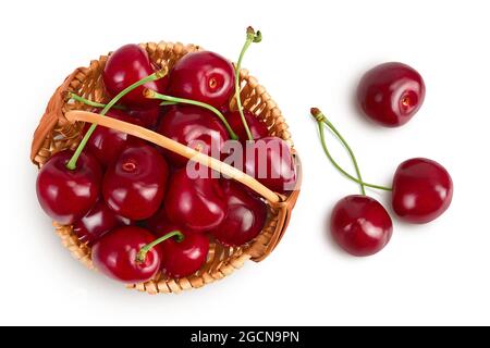 Cerisier rouge doux dans un panier en osier isolé sur fond blanc avec un chemin d'écrêtage et toute la profondeur de champ, vue de dessus. Pose à plat Banque D'Images