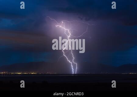 La foudre frappe Salt Lake City, dans l'Utah, alors qu'un orage dérive à travers le Grand Lac Salé dans les contreforts de la chaîne Wasatch Banque D'Images