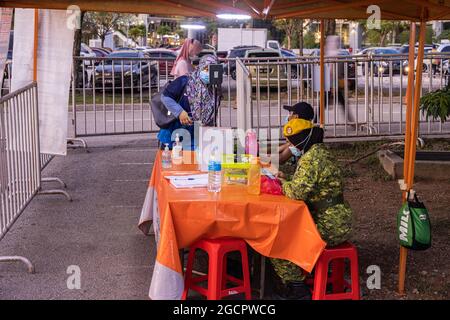 Contrôle d'entrée avec application pour smartphone et mesure de la température sur un marché frais à Putrajaya, près de Kuala Lumpur, pendant la crise Covid-19. Banque D'Images