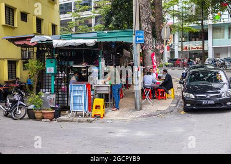 Kuala Lumpur, Malaisie - 04 octobre 2020 : magasins d'alimentation de rue dans le centre-ville de Kuala Lumpur. Clients assis sur des tables à côté de la route et déjeuner o Banque D'Images