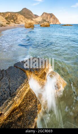 Vagues s'écrasant contre des rochers, plage de sable avec des falaises rocheuses, Paralia Paradisos, Kos, Dodécanèse, Grèce Banque D'Images