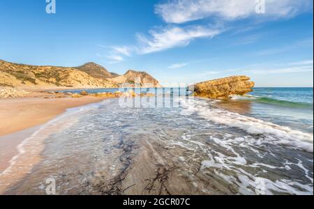 Rochers dans l'eau, vagues s'écrasant contre des rochers, plage de sable avec des falaises rocheuses, Paradisos Paralia, Kos, Dodécanèse, Grèce Banque D'Images