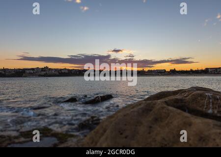 Littoral rocheux autour de la plage de Bondi, Sydney, Australie. Coucher de soleil près de la célèbre plage de surfeurs. Coucher de soleil sur l'océan pacifique. Le soleil se reflète dans le smoot Banque D'Images