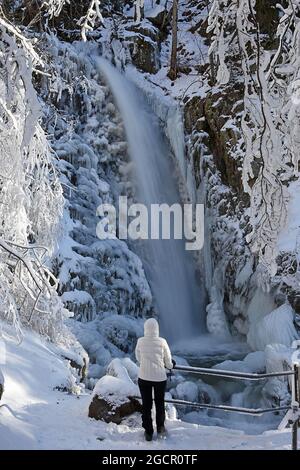 Randonneur devant une cascade glacée, paysage d'hiver, cascade de Todtnau, Feldberg, Forêt Noire, Bade-Wurtemberg, Allemagne Banque D'Images