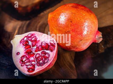 Un grenade près d'une table en bois tropical. Macro photographie des graines et du fruit entier. Structure du bois en arrière-plan. Détai Banque D'Images