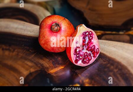 Un grenade près d'une table en bois tropical. Macro photographie des graines et du fruit entier. Structure du bois en arrière-plan. Détai Banque D'Images