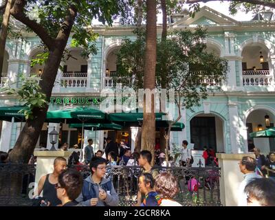 Le populaire Starbucks sur l'île de Shamian à Guangzhou a rempli de locaux et de touristes mais caché derrière des arbres. Banque D'Images