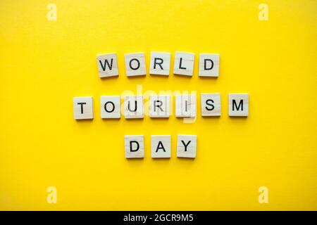 L'inscription Journée mondiale du tourisme à partir de blocs de bois sur fond jaune vif Banque D'Images
