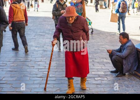 Lhassa, Tibet, Chine - 15 novembre 2020 : vieux Tibétains en vêtements tibétains traditionnels et bâton de marche. À des fins de prière, les personnes marchant sur le Banque D'Images