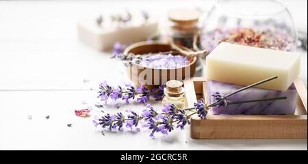 Savon de lavande et produits de spa avec fleurs de lavande sur une table blanche. Banque D'Images