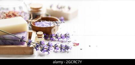 Les porte-savon de lavande et les produits de spa aux fleurs de lavande sur une table blanche. Banque D'Images