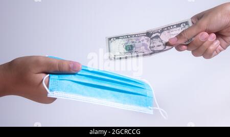 Masques de visage, la nouvelle monnaie aux Etats-Unis et dans le monde. Corona Cov19 crise fait le masque de bouche à l'équipement le plus recherché. Dollars et masque facial Banque D'Images