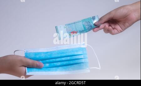 Masques faciaux, la nouvelle monnaie en Malaisie et dans le monde. Corona Cov19 crise fait le masque de bouche à l'équipement le plus recherché. Les prix ont augmenté. Femme Banque D'Images