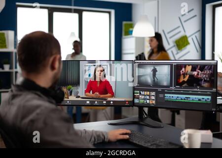 Éditeur vidéo dans la conférence de production en ligne Web avec le chef de projet sur l'édition de vidéo appel travail client, obtenir des commentaires sur le film d'entreprise en utilisant le logiciel de post-production sur deux moniteurs Banque D'Images