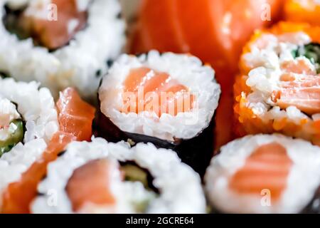 Manger divers sushis. Petits pains Maki, uramaki, hosomaki, sahimi et nigiri dans une assiette, en gros plan Banque D'Images