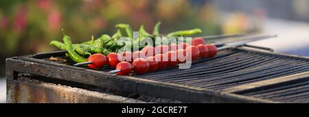 Tomates et poivrons frais sur les brochettes friture sur le gril gros plan Banque D'Images