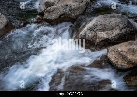 détail d'une rivière de montagne qui coule entre les rochers, effet de soie à exposition longue, horizontal Banque D'Images