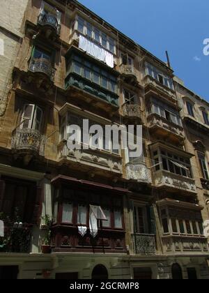 VALLETTA, MALTE - 14 juillet 2013 : un angle bas des balcons traditionnels en bois d'un bâtiment de haute hauteur à la Valette, Malte Banque D'Images