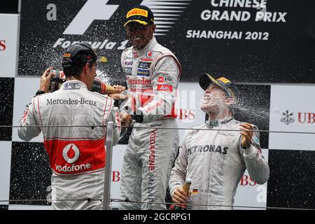 (De gauche à droite) : deuxième place Jenson Button (GBR) McLaren fête avec Lewis Hamilton (GBR) McLaren et Nico Rosberg (GER) Mercedes AMG F1 le champagne sur le podium. Grand Prix de Chine, dimanche 15 avril 2012. Shanghai, Chine. Banque D'Images