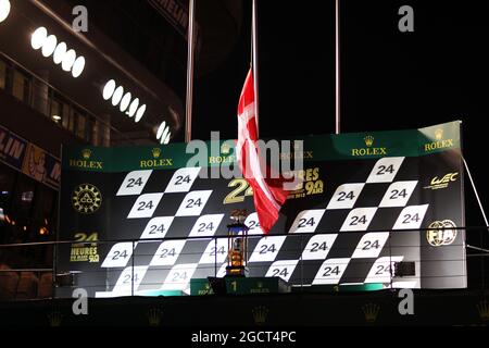 Le podium porte le drapeau danois à mi-mât pour rendre hommage à Allan Simonsen (DEN) Aston Martin Vantage V8, qui a subi un accident mortel dans la course. 24 heures du Mans, samedi 22 juin 2013. Le Mans, France. Banque D'Images