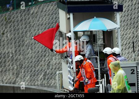 Les drapeaux rouges sont ondulés par des marshals à l'arrêt de la course. Grand Prix japonais, dimanche 5 octobre 2014. Suzuka, Japon. Banque D'Images