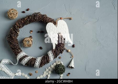 Décoration de Noël avec anneau en osier, lacets, ailes d'ange jouet sur fond de béton. Mariage, Noël texture rugueuse plat Banque D'Images