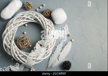 Décoration de Noël avec anneau en osier, lacets, plumes blanches sur fond de béton. Mariage, Noël texture rugueuse plat Banque D'Images