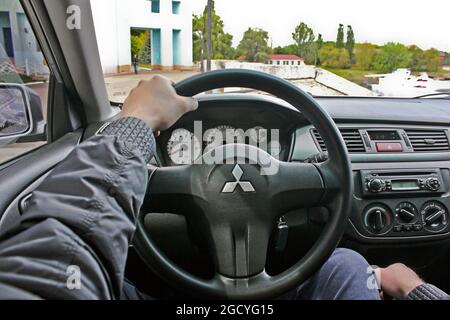 Chernigov, Ukraine - 6 mai 2014 : Mitsubishi lancer 9 génération. Service de luxe intérieur de voiture. Le conducteur garde ses mains sur le volant Banque D'Images