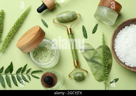 Soin de la peau beauté concept avec rouleau de visage sur fond vert Banque D'Images