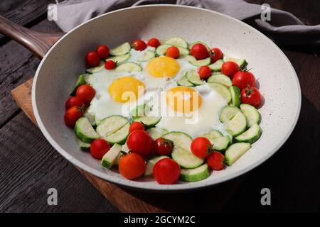 Petit déjeuner tardif, œufs frits avec courgettes, tomates cerises. Shakshuka dans une poêle sur fond rustique. Cuisine arabe. Nourriture casher. Banque D'Images