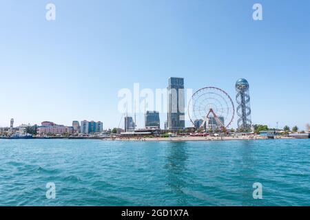 Batumi, Géorgie - 2 juillet 2021 : littoral de Batumi. Station balnéaire géorgienne populaire à la mer Noire. Vue panoramique sur la grande roue, la tour alphabétique, les gratte-ciels et la plage depuis la mer. Banque D'Images