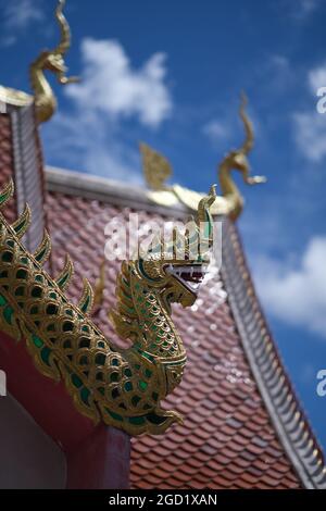 Un dragon sur la crête du toit du temple bouddhiste, et ciel bleu clair au-delà Banque D'Images