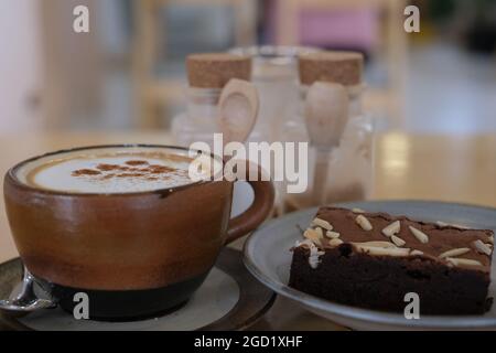 Une bonne tasse d'argile pleine de café et un délicieux brownie sur une plaque en céramique Banque D'Images