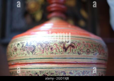 Une base de lampe, couverte de peintures traditionnelles thaïlandaises, représentant des personnages et des scènes mythologiques Banque D'Images