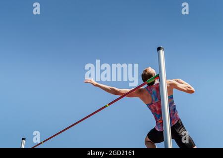 athlète haut saut sur fond bleu ciel Banque D'Images