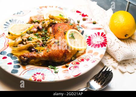 Picata italien de cuisse de poulet avec linguine, coeurs d'artichaut et câpres Banque D'Images