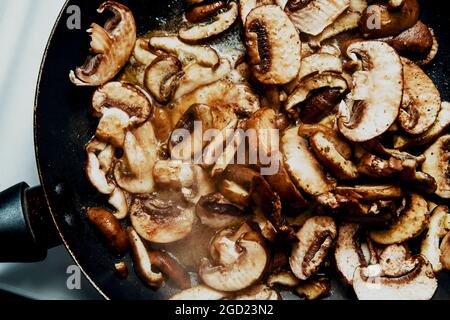 Faire sauter les champignons de la crème tranchés dans la poêle Banque D'Images