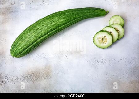 Concombre rayé arménien (Cucumis melo var. Flexuosus) sur fond de béton gris, vue du dessus, espace de copie Banque D'Images