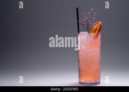 boisson de luxe à la limonade ou cocktail rose avec glace sur fond gris Banque D'Images