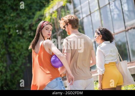 Vue arrière de trois jeunes marchant dans le parc Banque D'Images