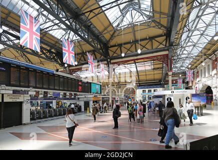 Le principal hall de la gare Victoria de Londres. Montre le panneau de départ, les barrières à billets et le toit voûté victorien. Banque D'Images