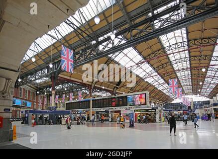 Le principal hall de la gare Victoria de Londres. Montre le panneau de départ, les barrières à billets et le toit voûté victorien. Banque D'Images