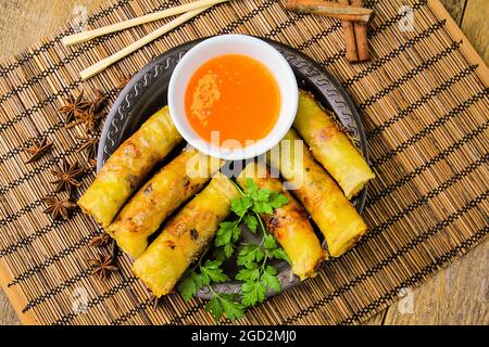 Vue de dessus des rouleaux de printemps chinois avec sauce douce sur l'assiette noire Banque D'Images